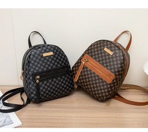Detailed view of mini floral patterned backpacks in black and brown on a wooden desk