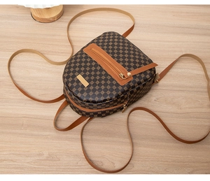 Detail of a brown mini backpack with geometric star prints and gold metallic zipper accents