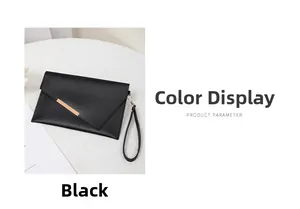 Macro shot of black envelope clutch bag featuring gold metal bar and textured leather