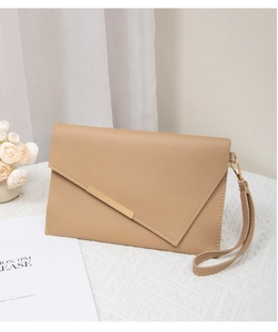 Detail shot of khaki envelope clutch featuring chic asymmetric flap and gold metal bar