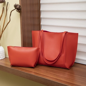 Grand cabas rouge minimaliste avec pochette assortie sur une étagère en bois