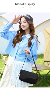 Outdoor model display of a black textured saddle bag paired with a blue striped shirt