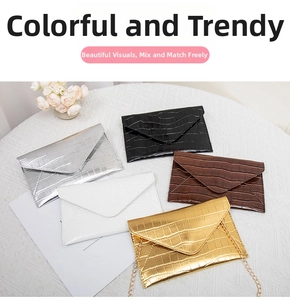 Flat lay of envelope clutch bags in crocodile texture with detachable metal chains
