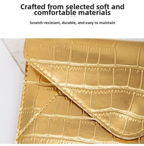 Detailed macro view of premium golden crocodile pattern texture on a stylish clutch bag