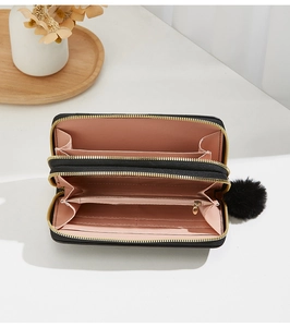 Detail view of double zipper long wallet with black leather and pink interior compartments