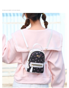 Detail of floral bow-knot printed mini backpack with gold zippers on pink uniform model
