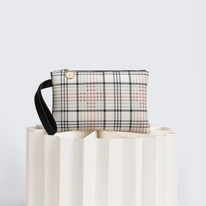 Close-up of checkered clutch bag with black leather wrist strap and golden zipper