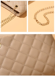 Macro detail of beige quilted leather bag with gold chain strap and stitching