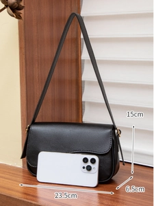 Detail view of black matte leather shoulder bag with dimensions 23.5x15x6.5cm on wooden table
