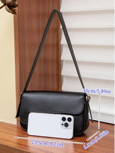Detail view of the black crossbody bag with dimensions and phone for size reference