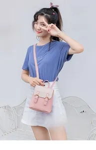 Detail of pink and white two-tone mini backpack featuring double buckle closure design