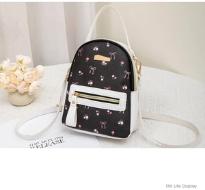 Detailed close-up of a mini floral backpack with pink bow prints and gold hardware detail