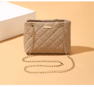 Close-up of quilted khaki leather bag showing gold chain strap and metal hardware