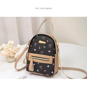 Detail view of mini backpack featuring pink bow floral print and gold metal zippers