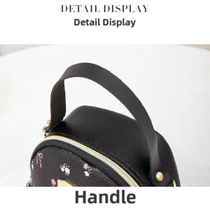 Detail of black leather handle with gold rivets and floral pattern on a mini backpack