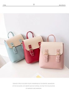 Close-up of mini two-tone backpacks in light blue, dark red, and pink with cream flaps