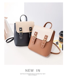 Detail view of two vintage-style mini backpacks with buckles in brown and black