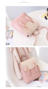 Detail of a mini pink and cream backpack featuring gold hardware and double buckles