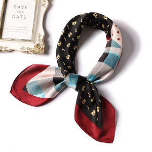 Detailed close-up of a satin scarf featuring cat patterns and classic plaid designs