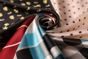 Close-up of silky paisley scarf fabrics featuring polka dots, cats, and plaid patterns