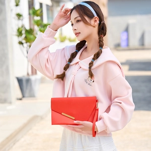 Fashionable bright red envelope clutch bag with gold metal trim and wristlet strap