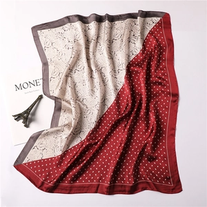 Detail of silk-feel scarf with paisley patterns, bicolored red and ivory with Monet art prop