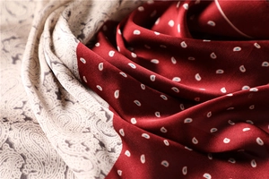 Macro detail of bicolored paisley scarf with smooth silk texture and fine stitching