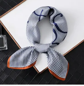Detail of blue houndstooth silk scarf with orange borders and abstract line patterns