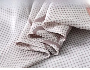 Macro view of houndstooth silk scarf showing delicate fabric texture and wavy patterns