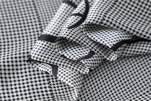 Close-up of black and white houndstooth silk scarf showing delicate fabric texture