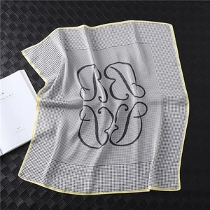 Detail of silk-like houndstooth scarf with yellow borders on leather background