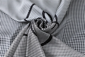 Macro view of houndstooth silk scarf showing fine weave texture and geometric black lines