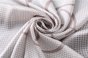 Detail of silk-like houndstooth scarf with pink and cream wavy patterns and soft satin luster