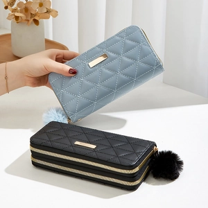 Quilted long wallets with pompom charms in gray-blue and black with dual zippers