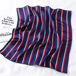 Detail of silk-textured square scarf featuring classic navy blue and red vertical stripes