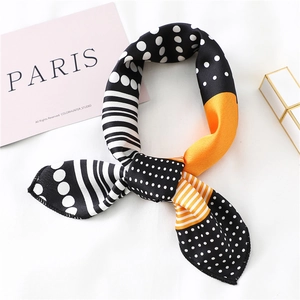 Close-up of geometric pattern silk scarf with black dots and orange color blocks