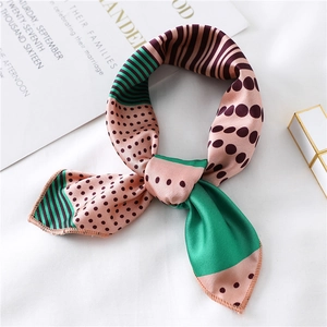 Macro detail of silk-like neckerchief with pink and green panels and purple polka dots