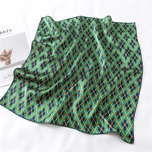 Detail of silk square scarf showing green and blue rhombus pattern and fine rolled hem edge