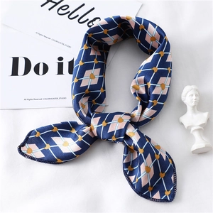 Detail showing elegant blue and pink geometric silk scarf tied in a stylish ring knot