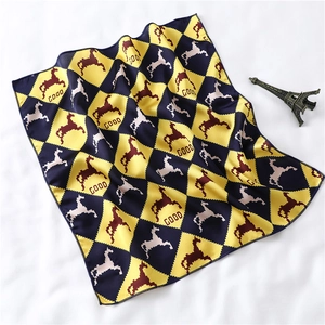 Close-up of silk-feel scarf with yellow and blue harlequin pattern and pixel horse detail