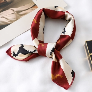 Elegant geometric patterned silk scarf in deep red and cream tied in a neat flat knot