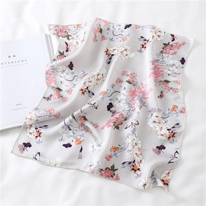 Detail of floral and butterfly print silk scarf with refined edge stitching and magazine