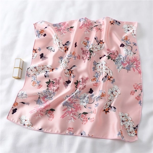 Detailed view of floral pink silk scarf with satin finish and butterfly pattern