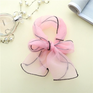 Detail einer rosa Organza-Haarschleife mit schwarzer Konturnaht und transparenter Optik