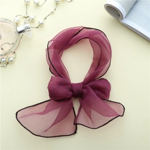 Detailansicht einer weinroten Chiffon-Schleife mit schwarzem Rand für das Haar