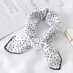 Detailed shot of white silk scarf with black polka dots and fine black edge stitching