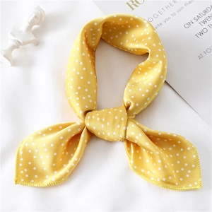 Close-up of yellow polka dot silk scarf with smooth texture and fine edge stitching