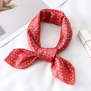 Detailed view of red silk scarf with white polka dots on elegant lifestyle background