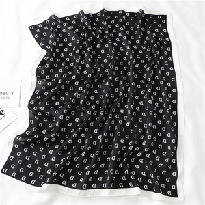 Chic black and white square silk scarf featuring a minimalist letter D pattern print