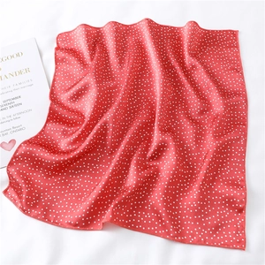 Detail of red and white polka dot silk scarf with elegant satin finish and fine edge stitching